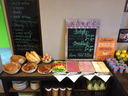 a table with some food and a chalk board at Garni HOTEL Fellini in Žiar nad Hronom