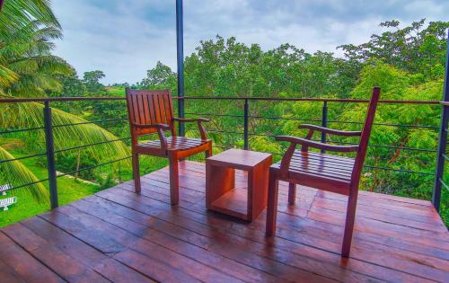 two chairs and a table on a wooden deck at Eliyanth Udawalawe in Udawalawe
