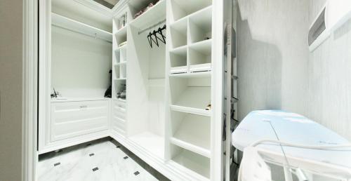 a white walk in closet with white shelves at Welcome to Poltava Apartments in Poltava