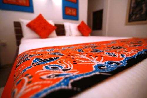 a bed with an orange and blue blanket on it at Eliyanth Udawalawe in Udawalawe
