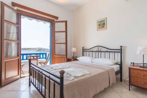 a bedroom with a bed and a large window at To Kima in Koufonisia