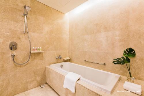 a bathroom with a bath tub and a shower at Fraser Suites Dalian in Dalian