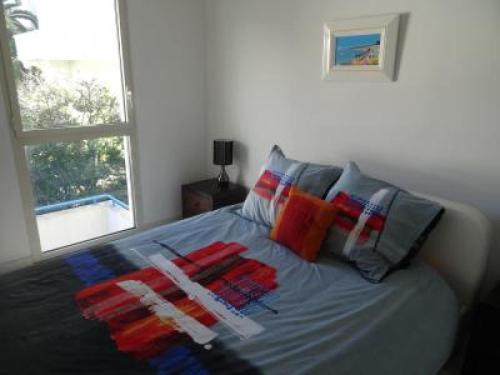 ein Bett mit bunten Kissen darauf im Schlafzimmer in der Unterkunft Modern one bedroomed apartment just off the Cannes Seafront with a terrace and pool access 1753 in Cannes