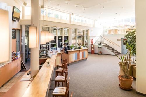 a large lobby with a long counter and chairs at JUFA Hotel Veitsch in Veitsch
