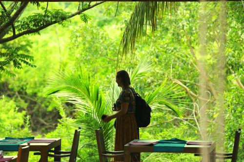 a woman with a backpack standing in a forest at Eliyanth Udawalawe in Udawalawe