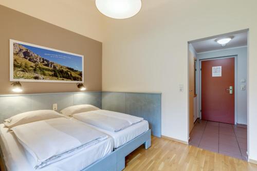 a bedroom with a large bed and a red door at JUFA Hotel Veitsch in Veitsch