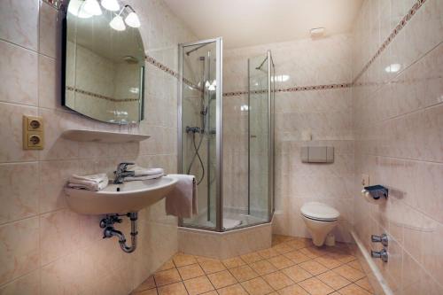 a bathroom with a shower and a sink and a toilet at Hotel Schiffmeister in Schönau am Königssee