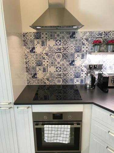a kitchen with blue and white tiles on the wall at Luxury apartment Spálená in Prague