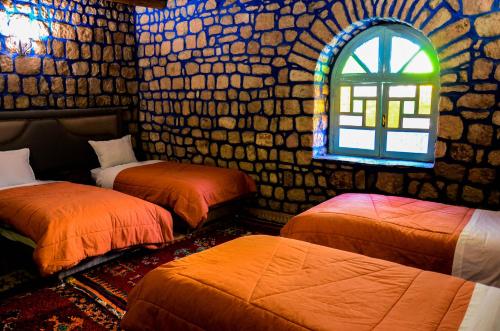 a room with two beds and a window at Riad Aslda in Asni