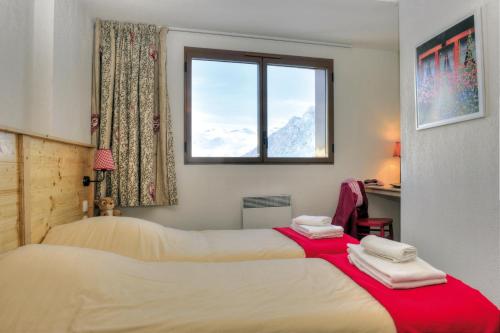 zwei Betten in einem Zimmer mit Fenster in der Unterkunft VTF Le Balcon de l'Alpe in L'Alpe-d'Huez