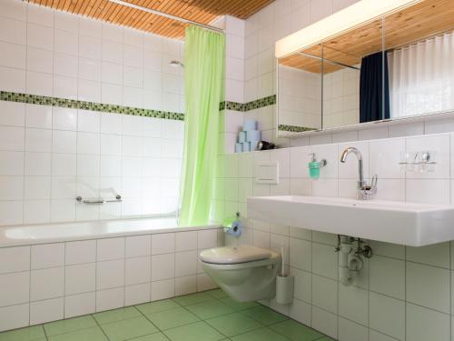 ein Badezimmer mit einem WC, einem Waschbecken und einer Badewanne in der Unterkunft Ferienwohnung Gästehaus Fürlauwi in Meien