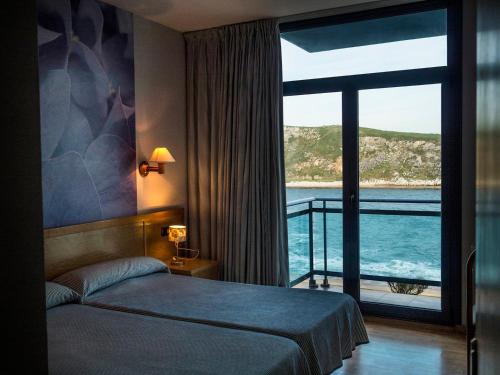 una camera d'albergo con un letto e una grande finestra di Hotel Soraya a Suances