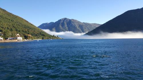 a large body of water with mountains in the background at Apartments Villa Swissmonte in Herceg-Novi
