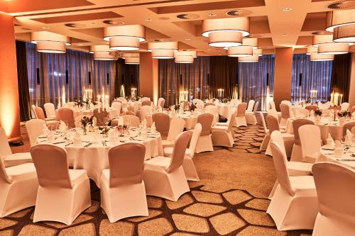 a banquet hall with white tables and chairs at Steigenberger Hotel Köln in Cologne