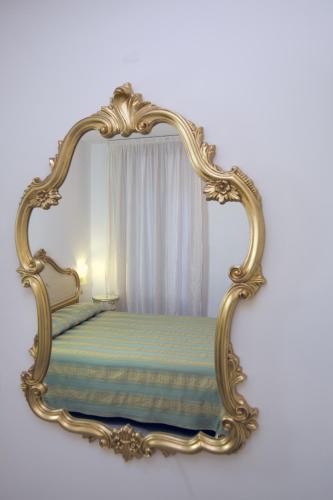 a mirror frame with a bed in a room at Hotel Orion in Venice