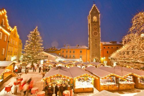 a christmas market in a town with a clock tower at Hotel Panorama in Fleres