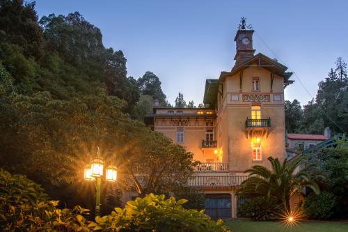 un edificio con una torre dell'orologio sopra di Chalet Relogio Guesthouse a Sintra