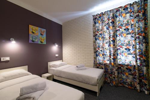 a hotel room with two beds and a curtain at Good Night Hotel in Odesa