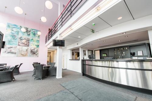 a lobby with a bar and chairs at Hotelli Messilä in Lahti