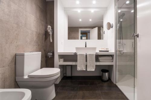 a bathroom with a toilet and a sink and a shower at Vincci Soma in Madrid