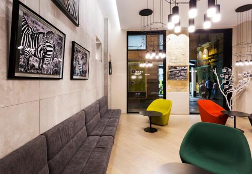 a lobby with a couch and colorful chairs at One Shot Mercat in Valencia