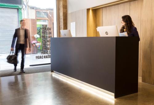 a woman standing at a counter with a laptop at One Shot Mercat in Valencia