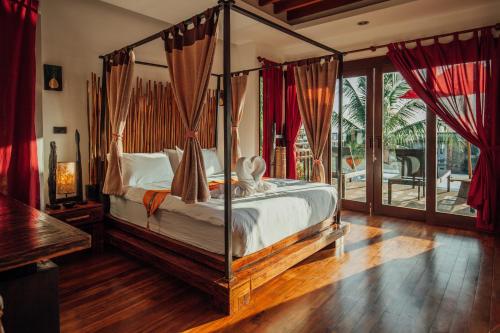 a bedroom with a canopy bed and a balcony at Thai Island Dream Estate in Ko Lanta