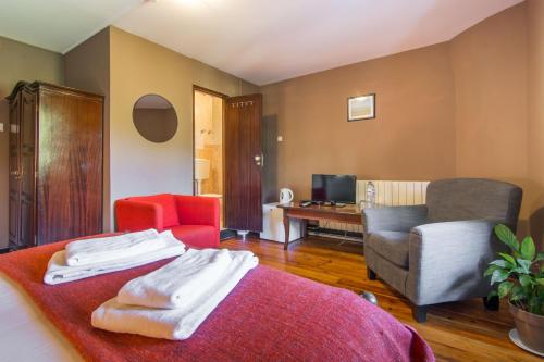 a room with a bed and a couch and a chair at Chalet Relogio Guesthouse in Sintra