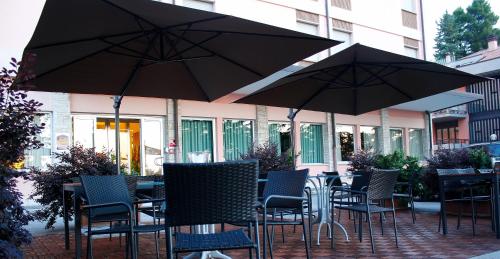 an outdoor patio with tables and chairs with umbrellas at Best Western Hotel I Colli in Macerata