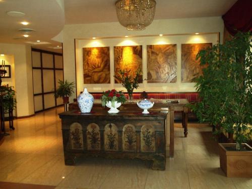 a lobby with a table with vases on it at Hotel Michelangelo in Sassuolo