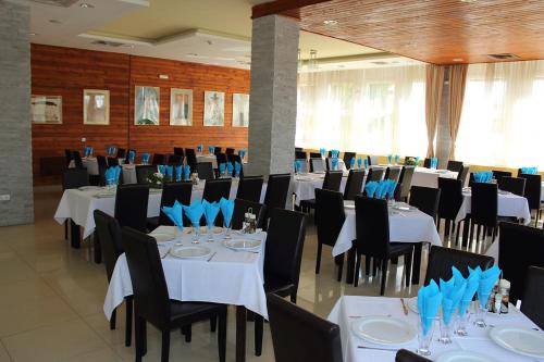 a banquet hall with white tables and black chairs at HOSTEL CPPI Nord in Buşteni