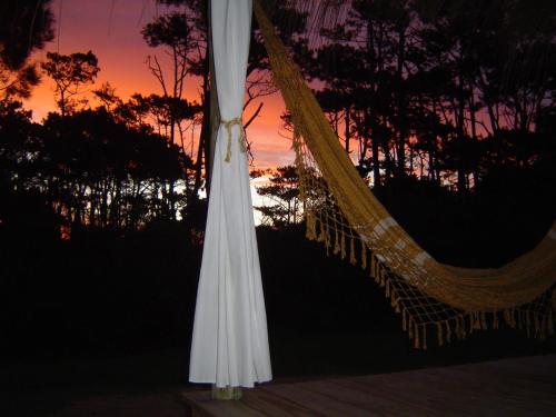 a hammock with the sunset in the background at Aloha Village in La Pedrera