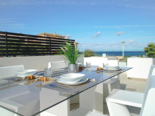 ソン・セッラ・デ・マリーナにあるBelvilla by OYO Atzurのダイニングテーブル(白い椅子付)が備わり、海の景色を望めます。