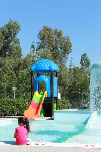 a little girl playing in a water park at Camping Village Baia del Marinaio in Vada