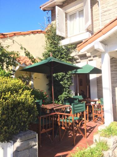 a group of tables and umbrellas on a patio at Hosteria Lucky Home in Mar del Plata
