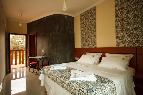 um quarto com uma cama com duas toalhas em Estrada Real Palace Hotel em Brumadinho