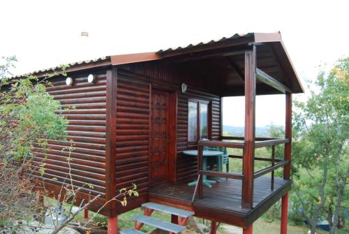 una piccola cabina in legno con una scala nel cortile di Camping de Cervera de Buitrago a Cervera de Buitrago