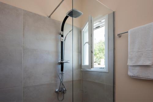 a shower in a bathroom with a window at Artheo Hotel in Kassiopi