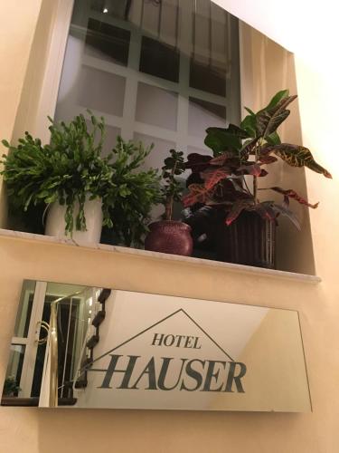 a shelf with plants and a hotel hauser sign on it at Hotel Hauser an der Universität in Munich