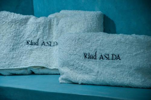 two towels with the words ruled aaq andoked aaqadj on them at Riad Aslda in Asni