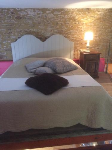 une chambre avec un grand lit blanc avec des oreillers dans l'établissement Studio Centre Historique Sarlat, à Sarlat-la-Canéda