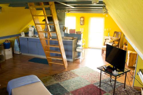 a living room with a staircase and a television at Ferienwohung II (Schardeich) in Pellworm