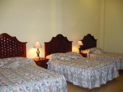 um quarto de hotel com duas camas e duas lâmpadas em Hotel Casa Cortes em Zacatecas