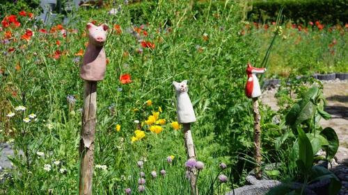 three wooden statues of cats in a garden at Gaestehaeuser Eva_Maria und Reinha in Hinrichshagen Hof