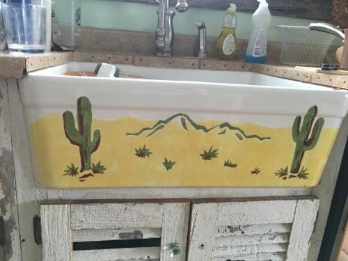 a sink with cacti and mountains painted on it at Schoolhouse Cabin in Gardiner