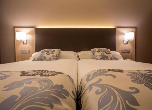 two beds sitting next to each other in a hotel room at Hotel Valentin in Aguilar de Campóo