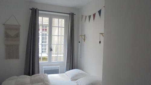 a bedroom with a bed next to a window at Le P'tit Appart De l'Orme in Saint Malo