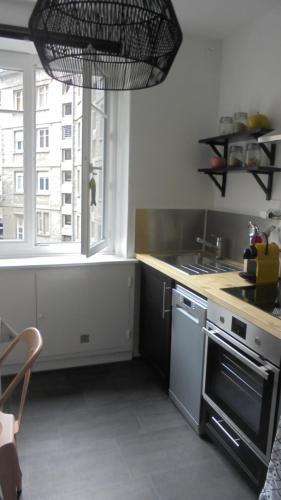 Il comprend une cuisine équipée d'une cuisinière et d'un évier. dans l'établissement Le P'tit Appart De l'Orme, à Saint-Malo