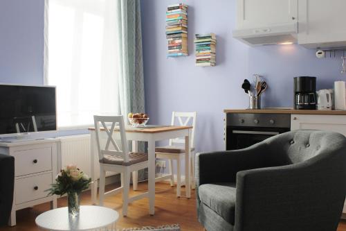 ein Wohnzimmer mit einem Tisch und Stühlen sowie eine Küche in der Unterkunft Apartment Flieder Zentral in Bremen