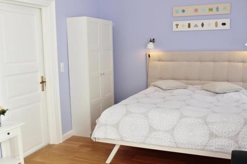 ein Schlafzimmer mit einem weißen Bett und einem weißen Schrank in der Unterkunft Apartment Flieder Zentral in Bremen
